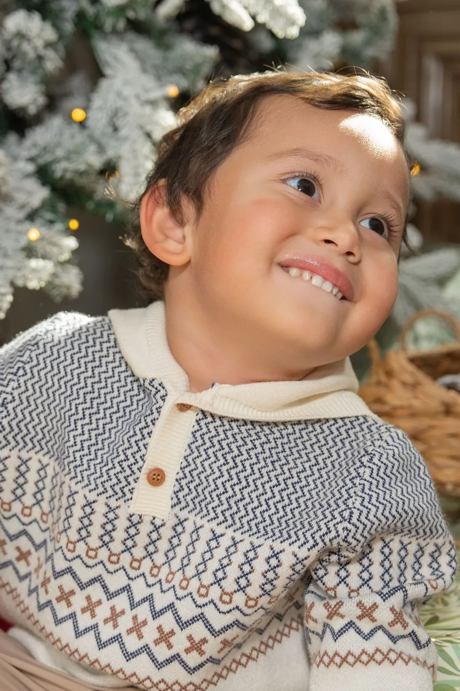 A child smiling beside holiday decorations